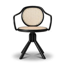 A modern barrel-style chair with a black curved frame, three legs, and a round woven cane backrest and seat, shown on a light gray studio background.
