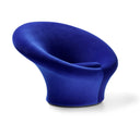 A modern sculptural armchair upholstered in a rich royal blue velvet fabric, shown from a three-quarters angle on a clean white background.