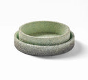Two nested round ceramic bowls with a textured speckled finish, featuring a light sage green interior and a dark gray exterior, set against a plain white background.