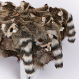 Stack of plush raccoon toys on a white background