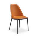 A modern dining chair with a curved, cushioned backrest and seat upholstered in warm cognac brown leather, supported by slim black metal legs, shown against a plain white background.