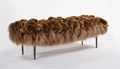 Bench covered with brown fur and teddy bears on a white background