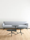 Three black Trampoliere Coffee Tables by Midj varying heights in front of a light gray sofa