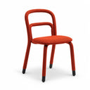A modern accent chair with a textured orange-red woven fabric, featuring a curved backrest and seat, supported by slim black legs with black caps, set against a plain white studio background.