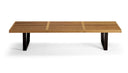 A modern outdoor bench with a light brown teak wood slatted seat and dark brown angled legs, shown from a front angle on a white background.