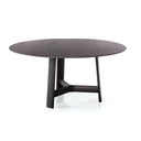 River round dining table by Bross with dark wood top and sculptural three-leg base