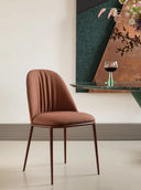 Midj Lea Deluxe S M TS dining chair in tan upholstered fabric beside a green stone table, high-resolution photograph