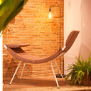Luxy Clop rust upholstered lounge seating with slender legs in warm brick-wall interior