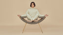 Clop Lounge Chair by Luxy with gray fabric upholstery, styled in a contemporary lounge with seated person