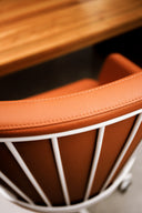 Detail of orange upholstery and exposed metal framework on a Luxy Italia Steel chair