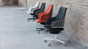 Luxy Italia Steel office chairs in an industrial loft setting, red and dark upholstery
