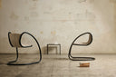 Timeless chairs by Luxy, sculptural cantilever steel loops with contrasting upholstery against a neutral interior