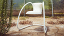 Luxy Timeless white upholstered chair with continuous tubular steel frame, architectural lifestyle view