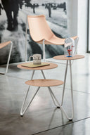 Midj Apelle Trio three-tier side table with round tops beside a hide-leather lounge chair