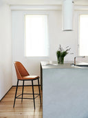 Midj Lea Deluxe M TS upholstered counter stool with black metal legs and tan seat beside a kitchen island