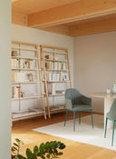 Midj Lea Deluxe P M TS upholstered armchair with curved arms and slender metal legs in a warm contemporary dining room