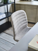 Midj Liu S ML TS side chair upholstered in light gray quilted fabric at a desk, close-up detail