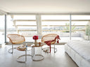 P47 family coffee tables in different heights between P47 chairs in a sunlit penthouse living room