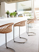Midj P47 M TS CU cantilever counter stools with natural leather lattice backs along a white kitchen island