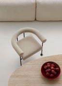 Midj Qua-ndo AP M TS cream upholstered lounge chair by a round wood coffee table in a pale interior