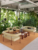 Midj Qua-ndo DV M TS curved-back sofa in cream upholstery arranged with matching chairs in a botanical interior