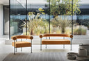 Midj Qua-ndo DV M TS sofa in golden brown upholstery against a glass wall with matching lounge seating