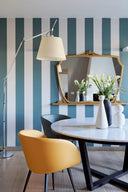 Mustard upholstered Midj Sonny P M TS M armchair with black metal legs in a dining room with striped blue walls
