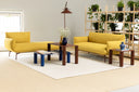 Midj Paw low coffee tables in blue and terracotta finishes arranged between yellow sofas in a bright lounge