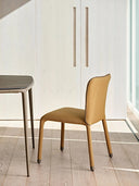 Midj S1 S R TS fully upholstered side chair in ochre beside a modern dining table