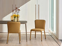 Two Midj S1 S R TS upholstered side chairs in mustard fabric on opposite sides of a dining table